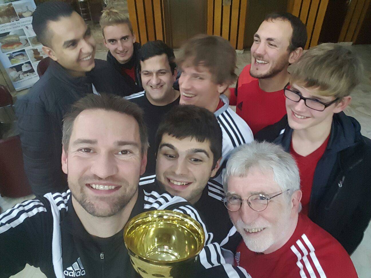Blindenfußball Nationalmannschaft mit Pokal als Selfie von schräg oben